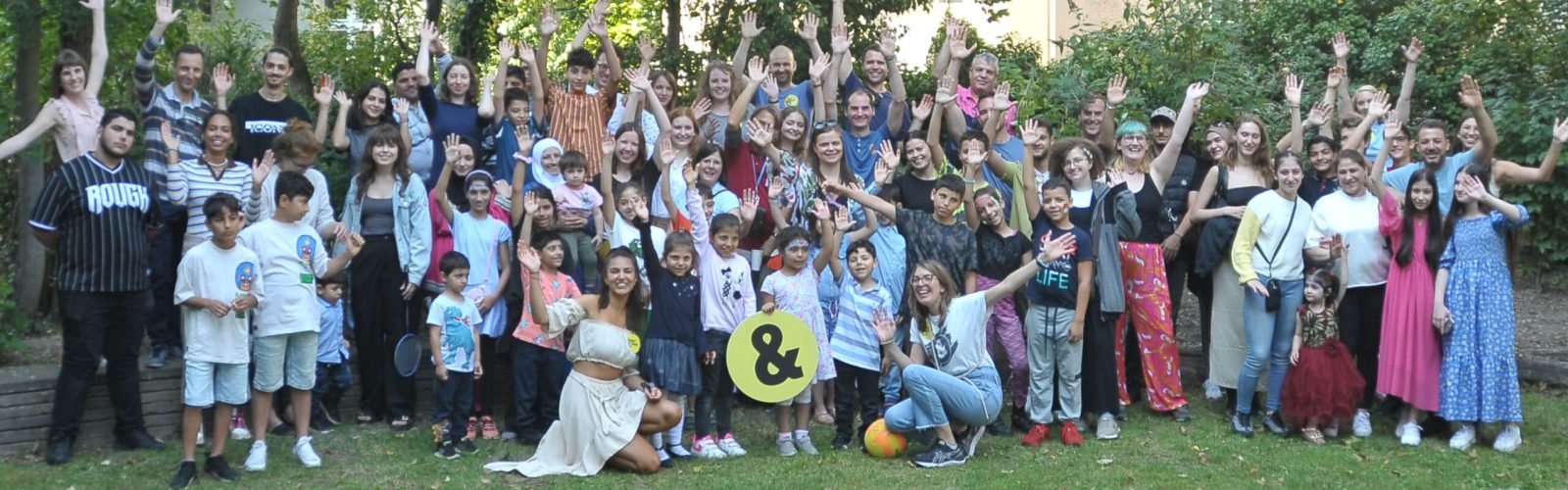 Gruppenfoto mit Pat*innen, Patenkindern und Familien beim Sommerfest 2023